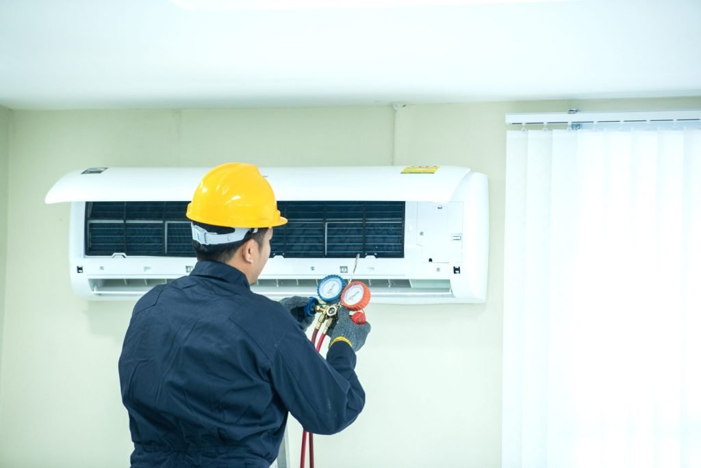 Technician servicing a wall-mounted aircon indoor unit