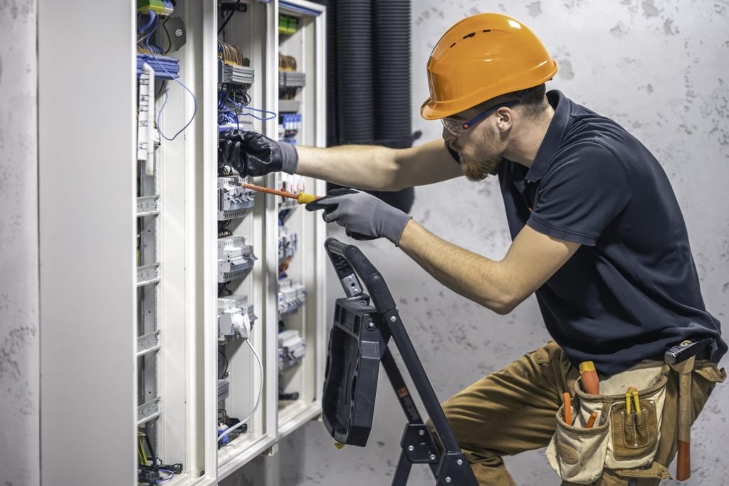 Electrician installing equipment in a distribution board